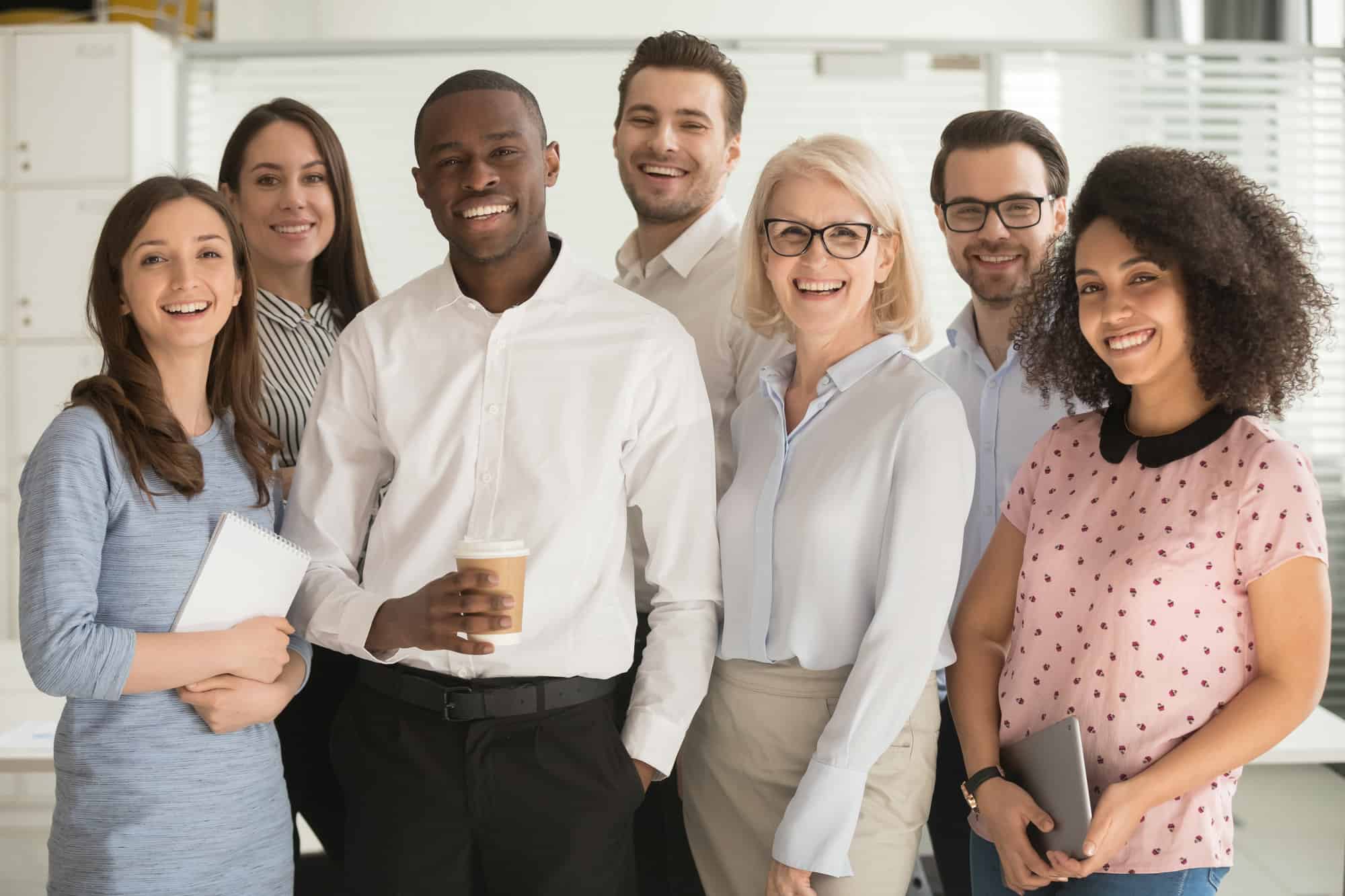 group of business professionals smiling wearing business attire